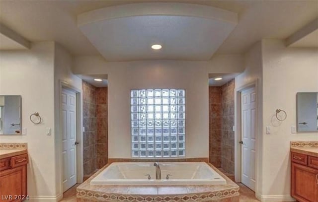 bathroom featuring vanity and a relaxing tiled tub