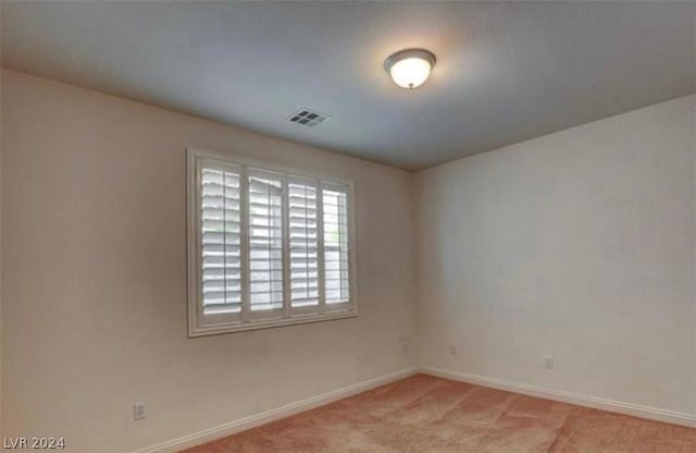 unfurnished room featuring light colored carpet