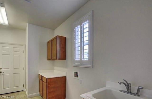 bathroom featuring tile patterned flooring, a bathing tub, and sink