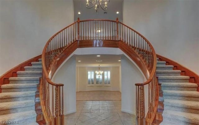 staircase with a high ceiling and a notable chandelier