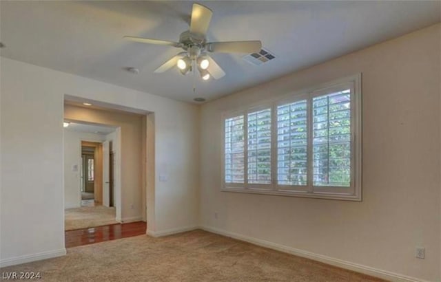 carpeted spare room featuring ceiling fan