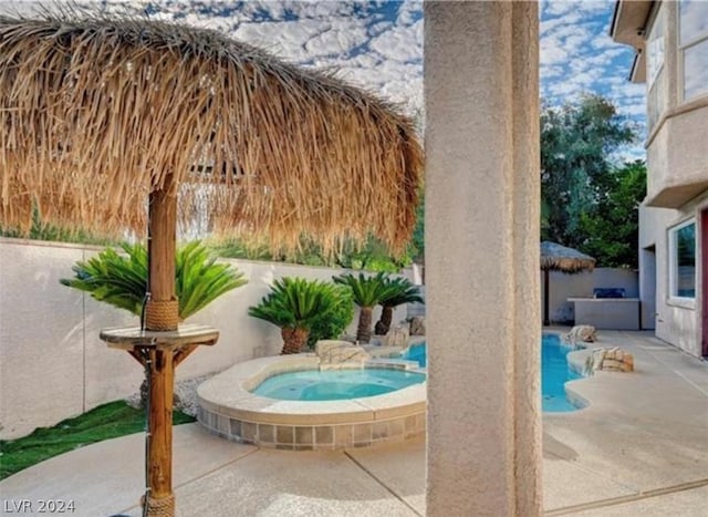 view of patio with a swimming pool with hot tub