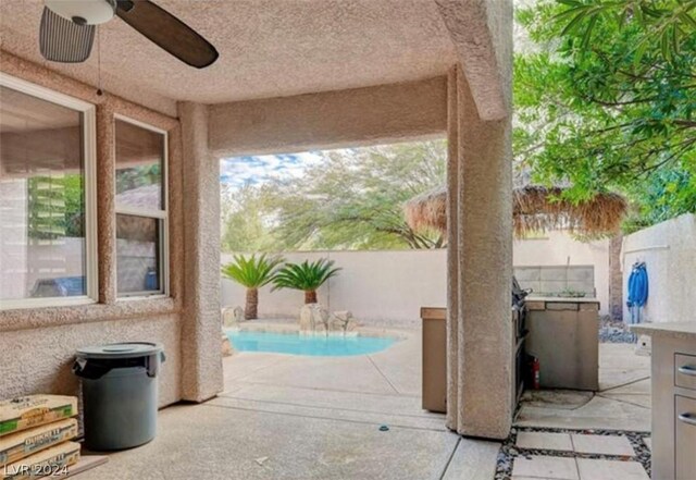 view of patio / terrace with ceiling fan and a fenced in pool