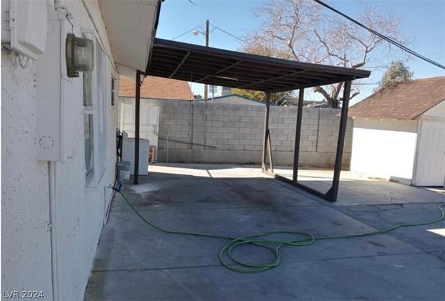 view of patio / terrace with a carport and an outdoor structure