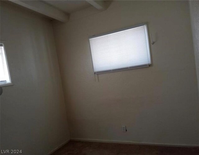 spare room featuring beam ceiling