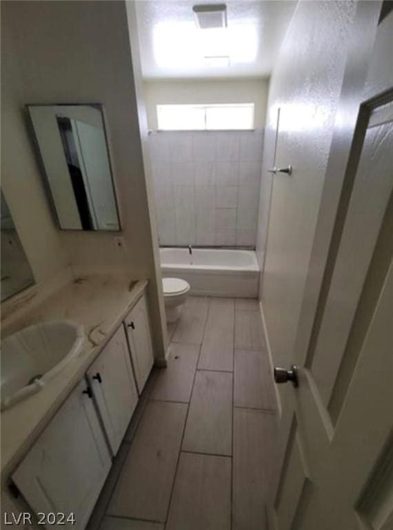 full bathroom featuring tile patterned floors, vanity, toilet, and tiled shower / bath