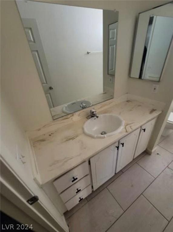 bathroom with tile patterned flooring, vanity, and toilet