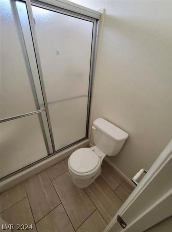 bathroom with an enclosed shower and toilet