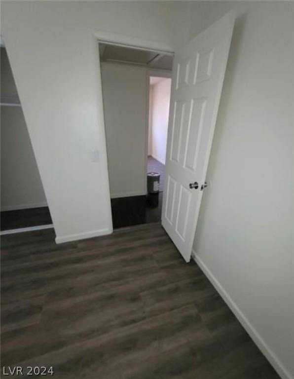 unfurnished bedroom featuring a closet and dark wood-type flooring