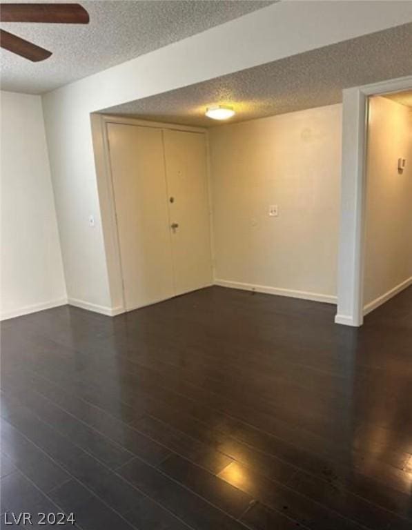 unfurnished room with a textured ceiling, dark hardwood / wood-style flooring, and ceiling fan