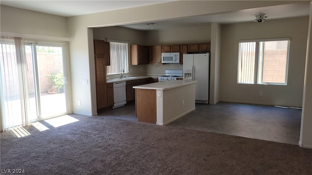 kitchen featuring a center island, sink, white appliances, and carpet flooring