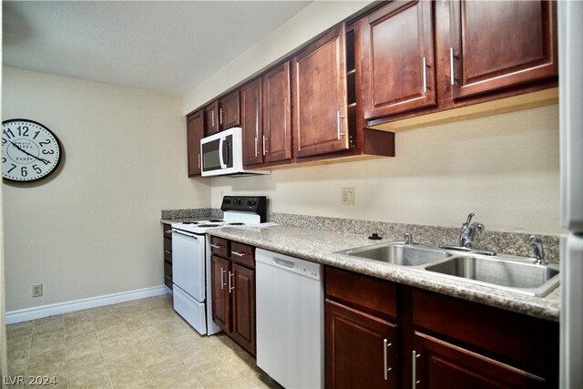 kitchen featuring sink, white appliances, and light tile floors