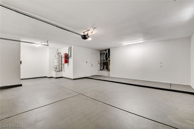 garage featuring strapped water heater and a garage door opener