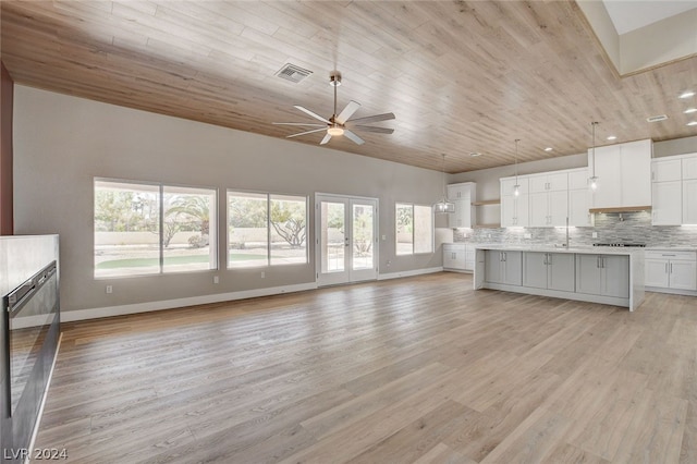 kitchen with white cabinetry, ceiling fan, tasteful backsplash, light hardwood / wood-style floors, and a kitchen island