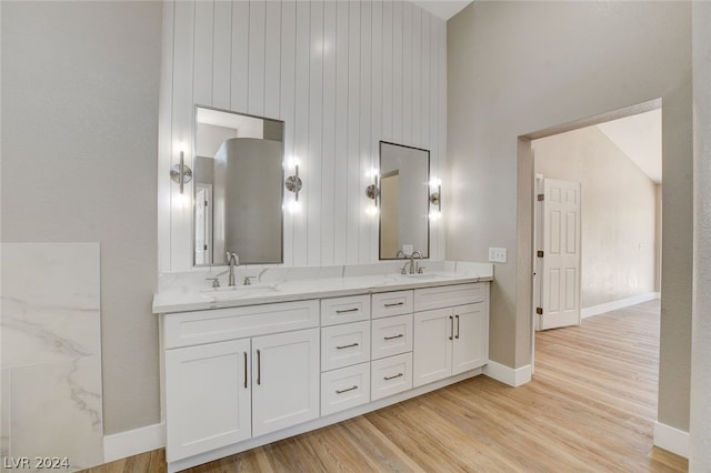 bathroom with wooden walls, vanity, high vaulted ceiling, and hardwood / wood-style flooring