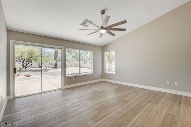 spare room with ceiling fan, vaulted ceiling, and light wood-type flooring