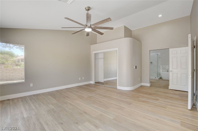 unfurnished bedroom featuring vaulted ceiling, ceiling fan, connected bathroom, light hardwood / wood-style floors, and a closet