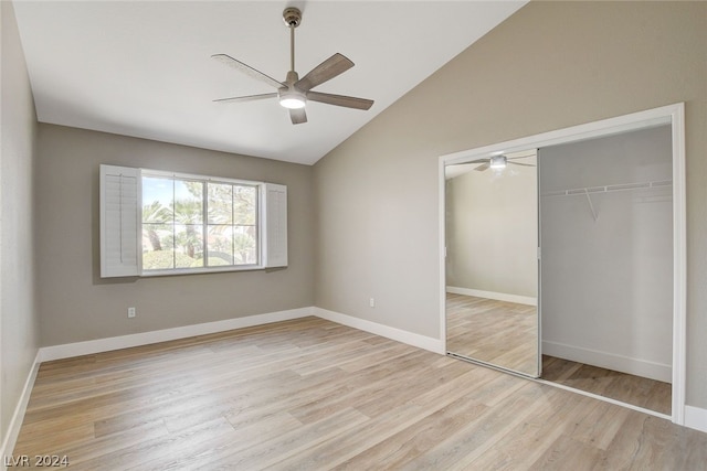 unfurnished bedroom with ceiling fan, vaulted ceiling, light wood-type flooring, and a closet