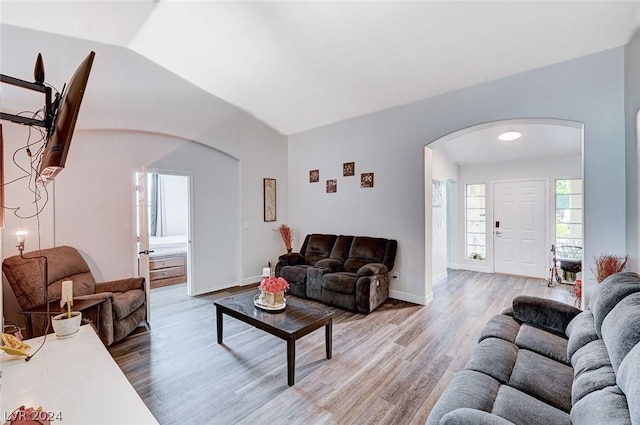 living room featuring lofted ceiling and light wood-type flooring