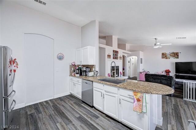 kitchen with sink, dark wood-type flooring, appliances with stainless steel finishes, white cabinetry, and kitchen peninsula