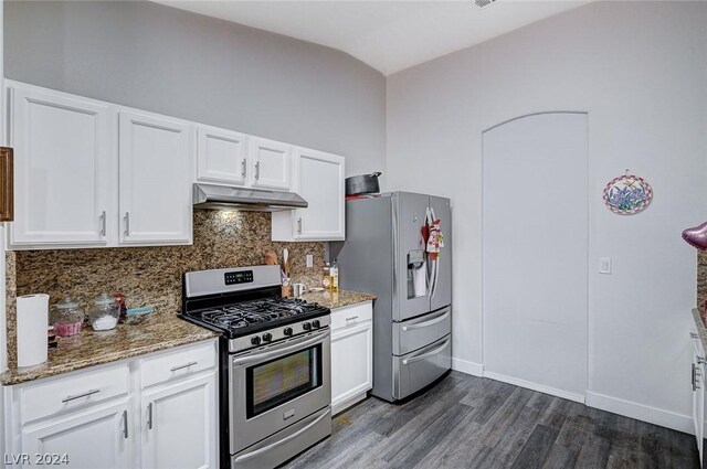 kitchen with appliances with stainless steel finishes, white cabinetry, dark hardwood / wood-style floors, stone countertops, and decorative backsplash