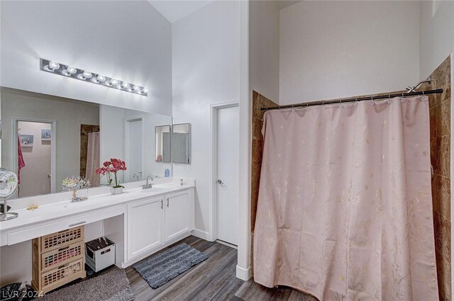 bathroom with vanity, curtained shower, wood-type flooring, and a high ceiling