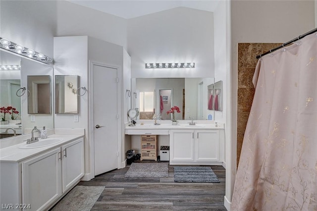 bathroom with vanity, lofted ceiling, hardwood / wood-style floors, and curtained shower