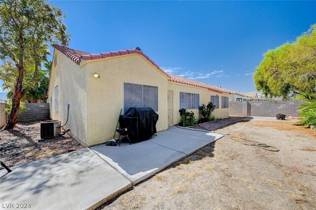 rear view of property featuring a patio and central air condition unit