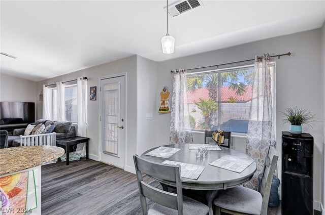 dining area featuring a healthy amount of sunlight and dark hardwood / wood-style flooring