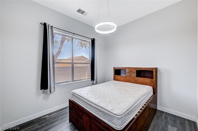 bedroom with dark hardwood / wood-style flooring