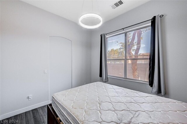 bedroom with dark hardwood / wood-style floors