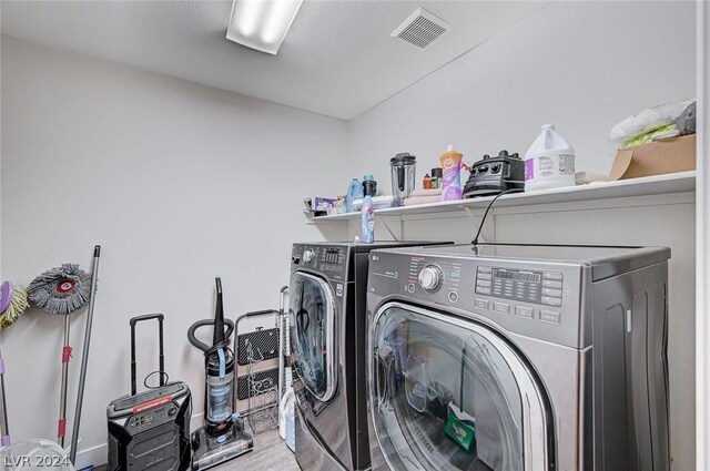 laundry room featuring wood-type flooring and washer and clothes dryer