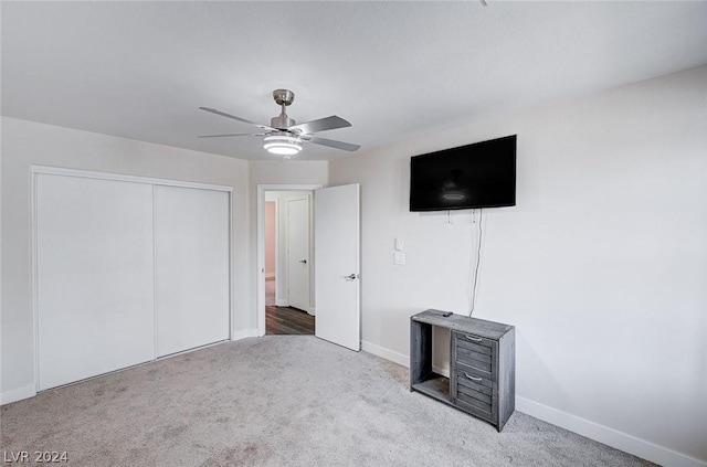 unfurnished bedroom featuring light carpet, ceiling fan, and a closet