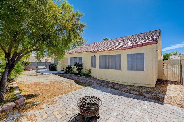 back of house with a patio and a fire pit