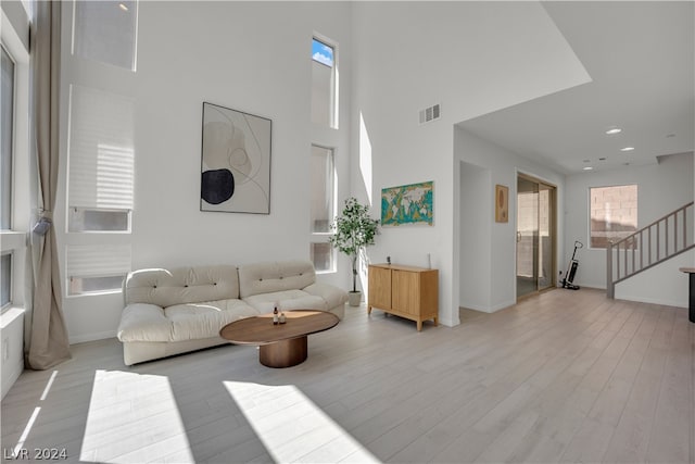 living room with a high ceiling and light hardwood / wood-style flooring