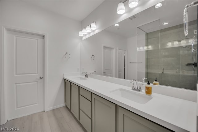 bathroom featuring walk in shower, dual vanity, and hardwood / wood-style floors