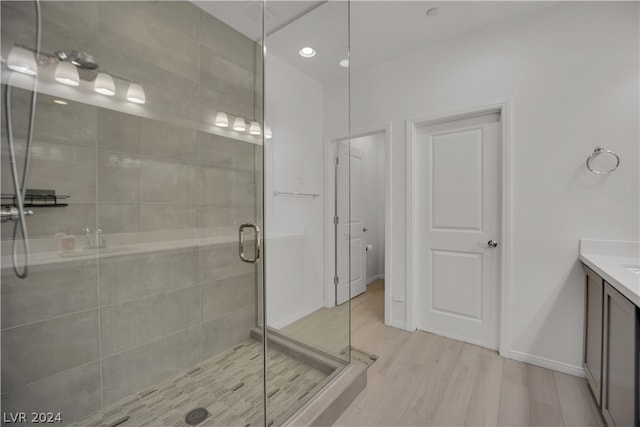 bathroom featuring walk in shower, wood-type flooring, and vanity