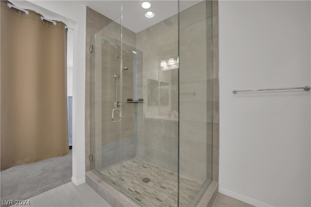 bathroom featuring a shower with door