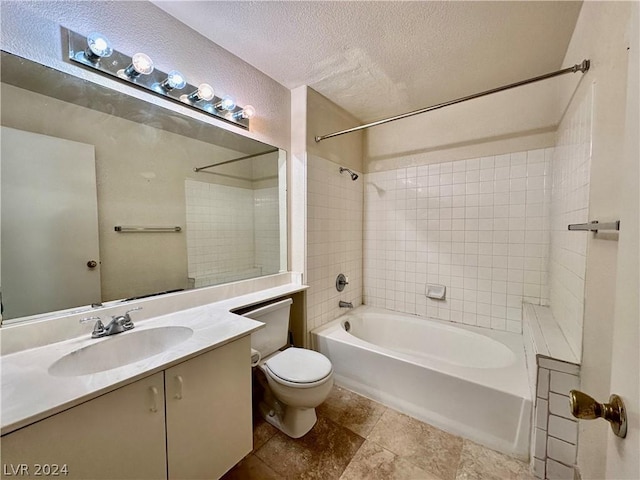 full bathroom featuring vanity, a textured ceiling, tiled shower / bath combo, and toilet