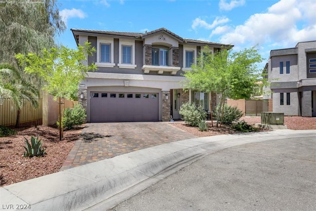 8373 Bartholomew Park Ct, Las Vegas, NV 89139 - view of front of house with fence, decorative driveway, a garage, stucco siding, and stone siding