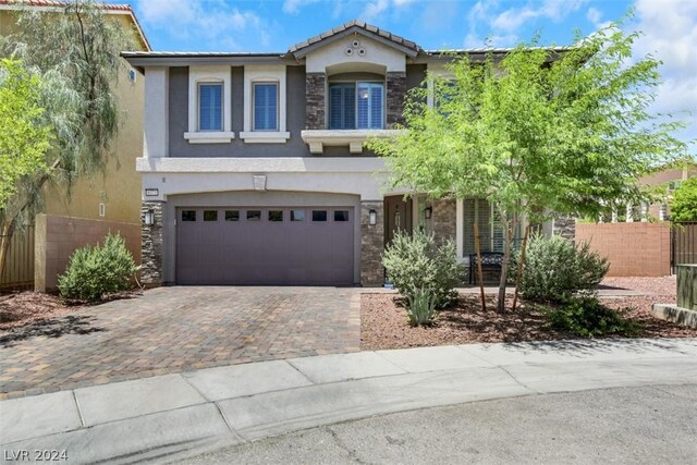 8373 Bartholomew Park Ct, Las Vegas, NV 89139 - traditional-style home with fence, an attached garage, stone siding, driveway, and stucco siding