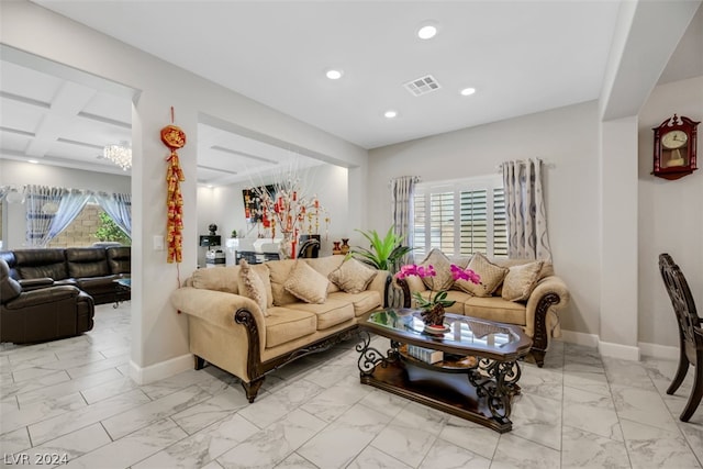 tiled living room featuring coffered ceiling and an inviting chandelier