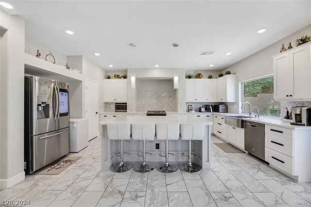 8373 Bartholomew Park Ct, Las Vegas, NV 89139 - kitchen featuring a breakfast bar area, visible vents, a sink, a kitchen island, and appliances with stainless steel finishes