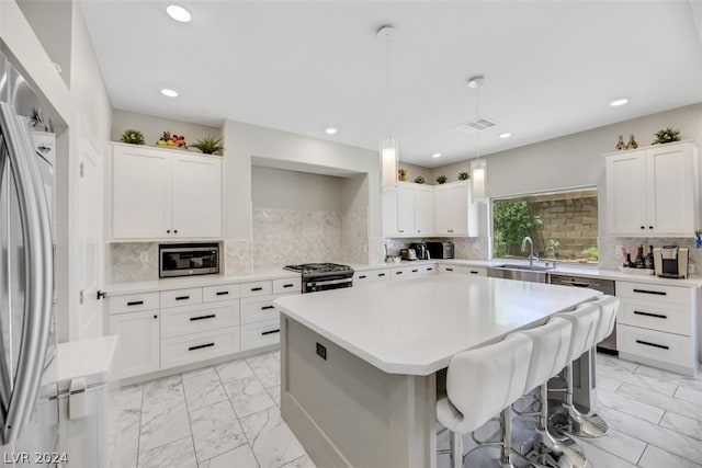 kitchen featuring hanging light fixtures, backsplash, light tile floors, and stainless steel appliances