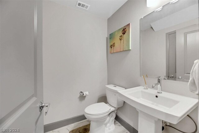 8373 Bartholomew Park Ct, Las Vegas, NV 89139 - half bathroom featuring toilet, a sink, visible vents, baseboards, and marble finish floor