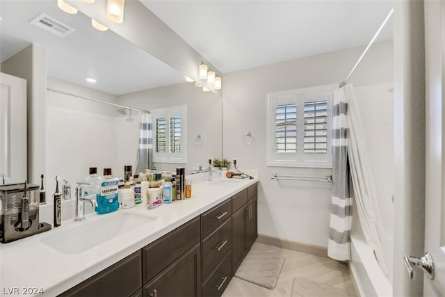 bathroom featuring a wealth of natural light, double vanity, tile flooring, and shower / tub combo with curtain