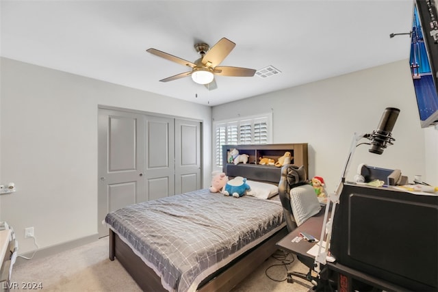 carpeted bedroom with ceiling fan and a closet