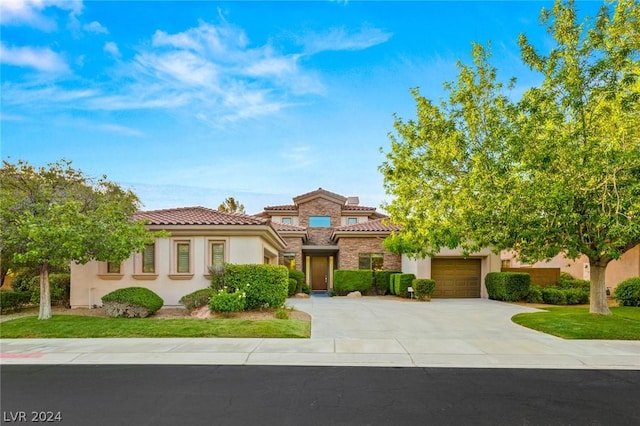 mediterranean / spanish-style home featuring a garage and a front yard