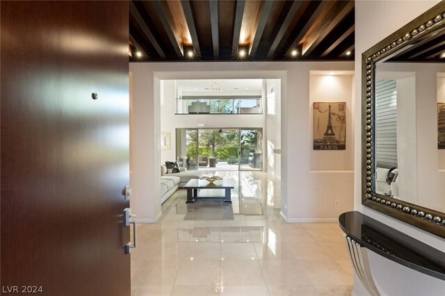 corridor with beam ceiling and light tile floors