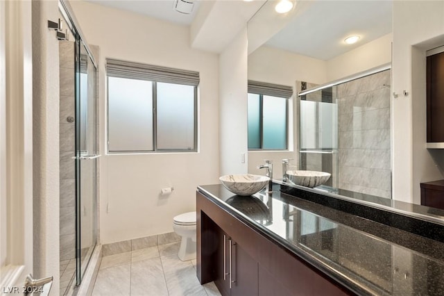 bathroom with vanity, a shower with shower door, and toilet